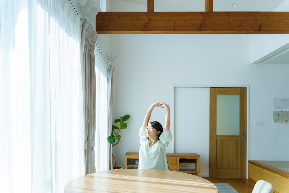 快適な室内で伸びをしている女性
