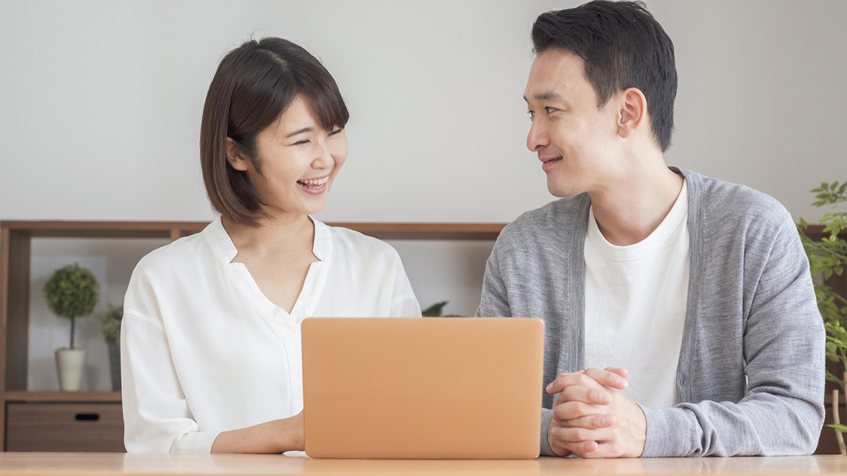 住宅購入の計画を立てるカップル。ノートパソコンを見ながら家づくりの優先事項を相談