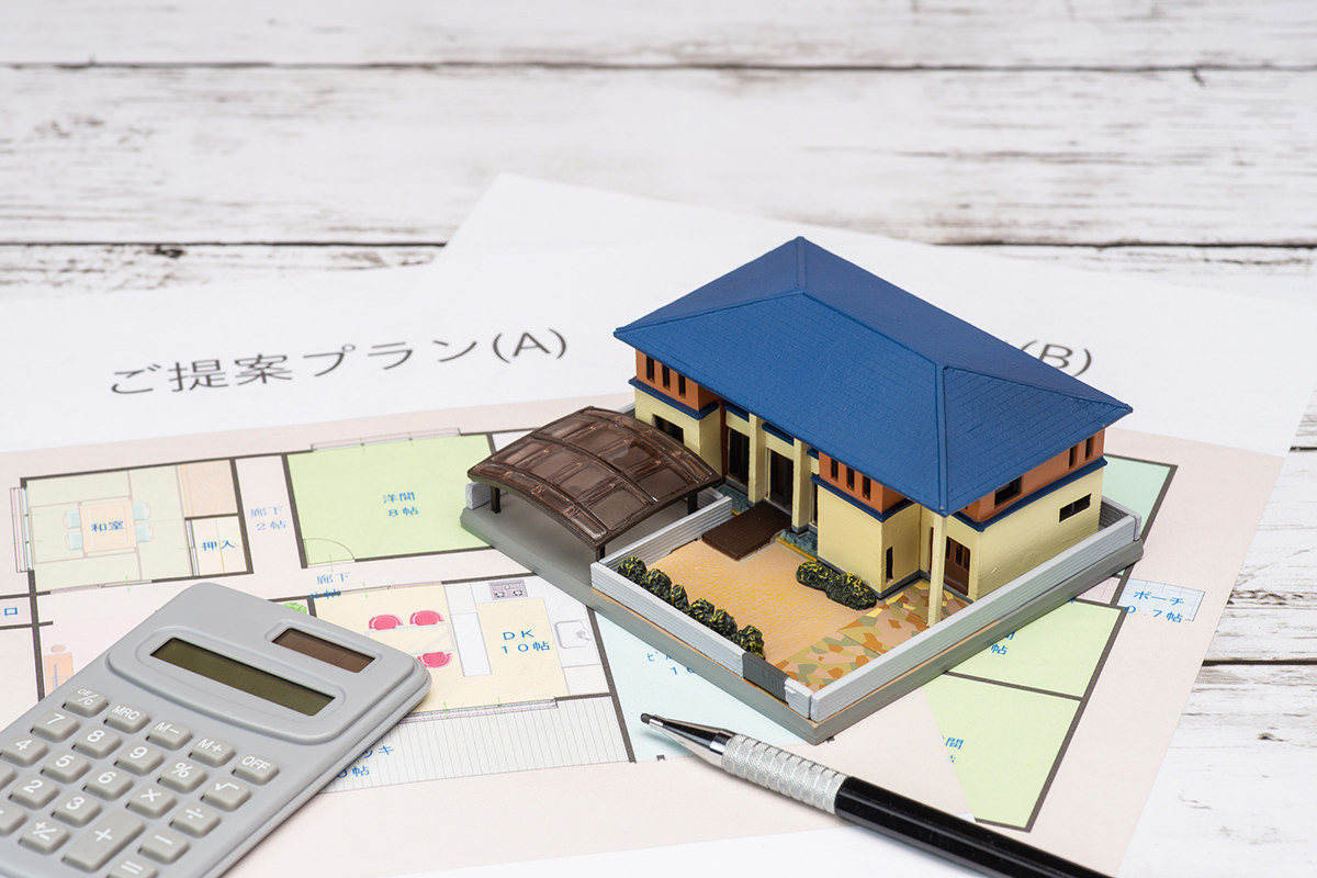 住宅の設計プランを比較。複数の間取り図と家の模型をチェック
