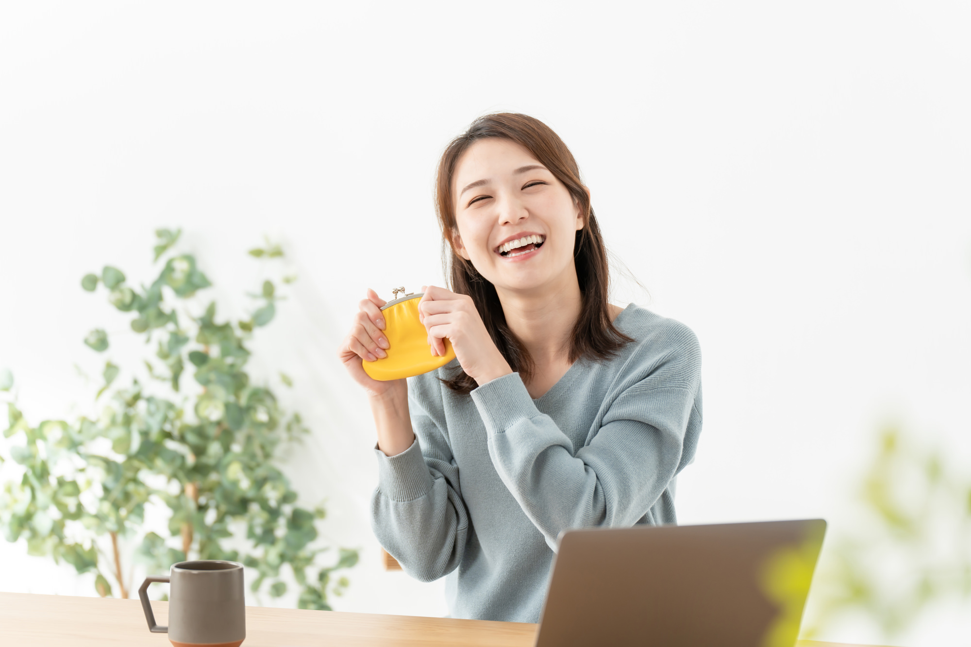 笑顔の女性がおさいふを持つ。住宅ローン控除の還付に喜ぶ様子